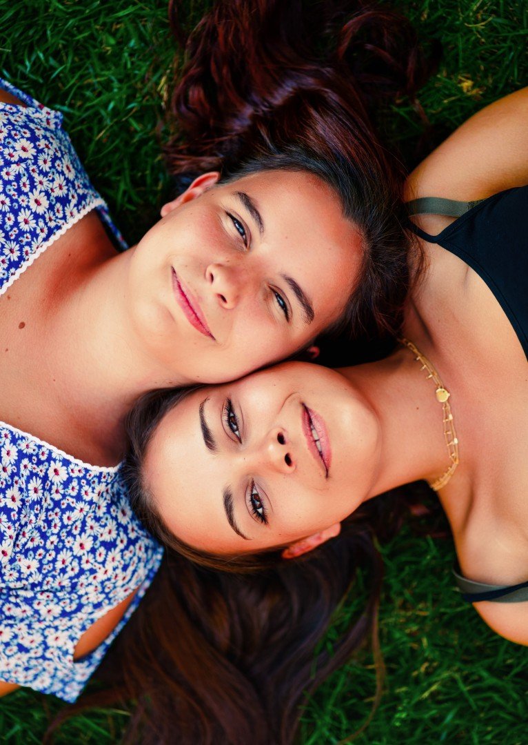 Deux femmes allongées dans l'herbe, souriantes